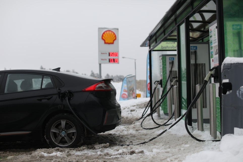 Bil som lader på energistasjon i vinteromgivelser